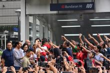 Le président indonésie Joko Widodo (deuxième à gauche) se fait prendre en photo par la foule en inaugurant le nouveau métro de Jakarta, le 24 mars 2019
