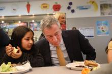 Le maire de New York Bill de Blasio déjeune dans une école de Brooklyn, le 11 mars 2019 à New York, où il a annoncé un programme de repas végétariens