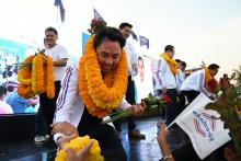 Itthipol Khunpleum reçoit des guirlandes de fleurs lors d'un meeting de campagne à Chonburi le 21 mars 2019, trois jours avant les élections