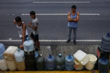 Des gens font la queue pour collecter de l'eau potable à Caracas le 10 mars 2019, au troisième jour d'une massive panne de courant qui menace les réserves alimentaires du pays