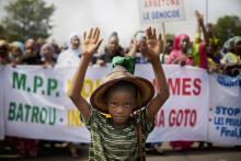 Un petit Peul manifeste devant une pancarte "arrêtons le génocide" lors d'une manifestation à Bamako, le 30 juin 2018.