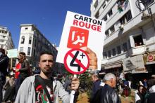 Des manifestants contre le pouvoir brandissent les messages sarcastiques en anglais "J'aime la manière dont tu mens" et "Je ne sais pas si c'est l'Algérie ou Bollywood", le 12 mars 2019 à Alger