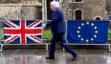 Un Londonien passe devant les drapeaux du Royaume-Uni et de l'Union européenne, près du parlement britannique, le 18 mars 2019