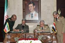 Photo distribuée par l'agence officielle syrienne Sana montrant le ministre de la Défense Abdallah Ayoub (D) et son homologue iranien Amir Hatami, lors de la signature d'un accord de coopération le 26
