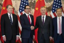 Le vice-premier ministre chinois Liu He et le secrétaire américain au Trésor Steven Mnuchin se serrent la main, entourés du représentant américain au Commerce Robert Lighthizer et du govuerneur de la 