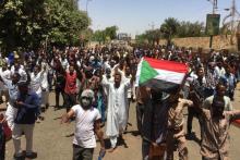 Des manifestants soudanais entourent un véhicule de l'armée à Khartoum, le 8 avril 2019