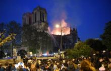 Des badauds sont massés sur les quais alors que Notre-Dame brûle, à Paris le 15 avril 2019