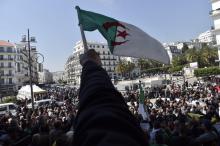 Un Algérien brandit le drapeau national lors d'une manifestation contre le pouvoir, le 3 avril 2019 à Alger