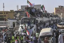 Des manifestants soudanais sur et à proximité d'un train arrivant dans la capitale Khartoum, le 23 avril 2019