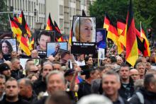 Des portraits de victimes de migrants brandis lors d'une manifestation organisée par Alternative pour l'Allemagne (AfD) le 1er septembre 2018 à Chemnitz
