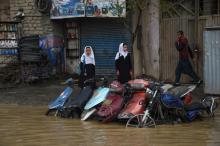 Des passants cherchent à se mettre au sec après des pluies torrentielles à Kaboul