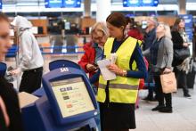 Une employée aide un voyageur devant une borne d'enregistrement pendant une grève des pilotes de Scandinavian Airlines (SAS) le 26 avril 2019 à l'aéroport de Kastrup au Danemark