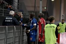 Le capitaine amiénois Prince Désir Gouano (g) se rapproche des supporters après des cris racistes à son égard et l'interruption pendant quelques minutes du match face à Dijon le 12 avril 2019
