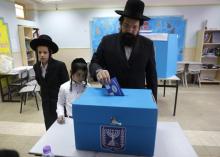 Un juif ultra-orthodoxe glisse son bulletin de vote dans un bureau de Jérusalem à l'occasion des législatives israéliennes le 9 avril 2019