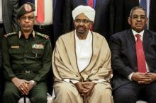 Le président soudanais déchu Omar el-Béchir (au centre) est assis aux côtés de son ancien ministre de la Défense, Awad Ibn Ouf (à gauche) et de l'ancien Premier ministre Mohamed Tahir Eila (à droite),