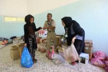 Des personnes chassées de leurs maisons par les combats recoivent de l'aide alimentaire dans une école transformée en refuge dans un faubourg au sud de Tripoli, le 17 avril 2019