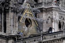 Des ouvriers installent des bâches de protection sur le toit de Notre-Dame de Paris, le 23 avril 2019