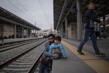 Un migrant et son enfant manifestent dans la principale gare d'Athènes le 5 avril 2019