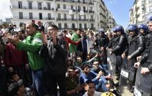 Des jeunes Algériens entonnent des slogans devant des forces de sécurité durant une manifestation contre le pouvoir, le 9 avril 2019 à Alger