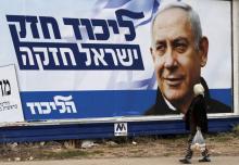 Une arabe israélienne marche devant une affiche électorale montrant le Premier ministre israélien Benjamin Netanyahu, à Haïfa (nord), le 4 avril 2019