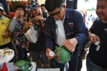 Un homme sert du thé au cannabis lors d'un festival dédié à la marijuana dans la province du Buriram en Thaïlande, le 20 avril 2019