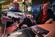 Les propriétaires d'un bar de Bully-les-Mines, posent avec les photos d'Emmanuel Macron en visite dans la ville en 2017 et 2018, le 2 avril 2019