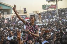 Des manifestants venus de la ville d'Atbara (centre du Soudan) font le signe de la victoire en arrivant en train à Khartoum le 23 avril 2019