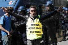 Un militant porte une pancarte avec l'inscription "Macron, notre drame français" en référence à l'incendie qui a dévasté Notre-Dame de Paris, le 20 avril 2019