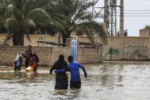 Des Iraniens tentent de se déplacer dans un village inondé près de la ville d'Ahvaz, dans la province de Khouzestan, le 31 mars 2019
