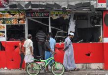 Des passants devant un magasin saccagé, au lendemain d'émeutes anti-musulmans à Minuwangoda au Sri Lanka le 14 mai 2019