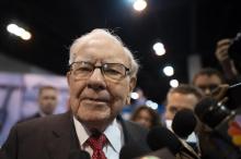 Des actionnaires posent auprès d'une effigie grandeur nature du milliardaire américain Warren Buffett, PDG de Berkshire Hathaway, lors de l'assemblée générale du groupe à Omaha (Etats-Unis), le 3 mai 