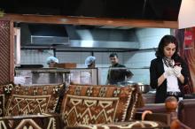 Une serveuse afghane consulte son téléphone dans le restaurant Afghan Kebab à Esenyurt, un distrcit d'Istanbul le 11 avril 2019