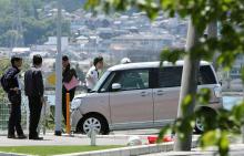 Des policiers inspectent la voiture qui a heurté un groupe d'enfants, le 8 mai 2019 à Otsu, près d'Osaka, au Japon