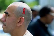 Un homme avec le ruban rouge symbolisant le sida participe à la journée mondiale contre le sida à Caracas au Venezuela le 1er décembre 2001