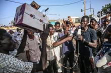 Un Soudanais joue eu reporter au sit-in des manifestants appelant à un gouvernement de civils devant le QG de l'armée à Khartoum, le 29 avril 2019