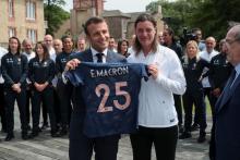 Le président Emmanuel Macron s'est vu remettre un maillot à son nom par la sélectionneure des Bleues Corinne Diacre, sous le regard des joueuses, le 4 juin 2019 à Clairefontaine