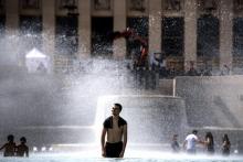 Des jeunes se rafraîchissent dans une fontaine de l'esplanade du Trocadéro à Paris, le 24 juin 2019