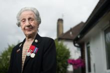 Marie Scott, une ex-standardiste de 92 ans, le jour J pose avec sa légion d'honneur devant sa maison à Londres le 31 mai 2019