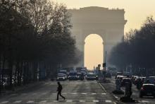 Des véhicules circulent à Paris près de l'Arc de Triomphe le 23 janvier 2017