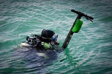 Un plongeur volontaire remonte une trottinette jetée à l'eau à Marseille le 20 juillet 2019