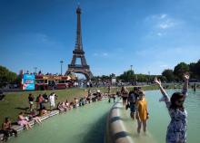 Des personnes se rafraîchissent dans la fontaine du Trocadéro, en face de la Tour Eiffel, le 2 août 2018 à Paris