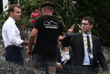 Emmanuel Macron (g)salue un habitant de Tourmalet lors de la 14e étape du Tour de France entre Tarbes et le col du Tourmalet, le 20 juillet 2019