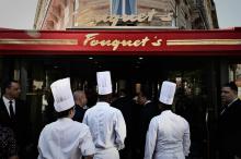 Les employés du restaurant Le Fouquet's sur les Champs Elysés à Paris posent le 13 juillet 2019 devant la brasserie à la veille de sa réouverture