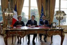Le président Macron signe le 22 septembre 2017, entouré de Muriel Pénicaud, ministre du Travail, et de Christophe Castaner, ministre des Relations avec le Parlement, les ordonnances instaurant un barè