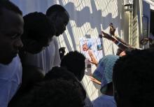 Des migrants recueillis par le navire Ocean Viking lisent des articles de presse les concernant, le 21 août 2019