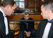 Mes Pierre Alfort (D) et Laurent Boguet (G) s'entretiennent avec leur client, le tueur en série présumé Patrice Alègre (C), le 21 février 2002 dans la salle d'audience de la Cour d'assises du tribunal