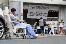 Un patient assis devant l'entrée des services d'urgence de l'hôpital de Saint-Martin-en-Ré à La Rochelle, en France, le 12 juillet 2019