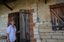 Christelle Chaloyard se tient devant sa maison affectée par la sécheresse à Savigny-en-Revermont le 14 août 2019