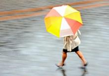 Une femme sous la pluie avec un parapluie.