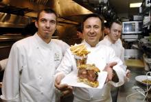 Le chef français Daniel Boulud (C), avec son second Olivier Muller, présente son burger - "The Original db Burger" - dans son restaurant de New York le 14 avril 2006